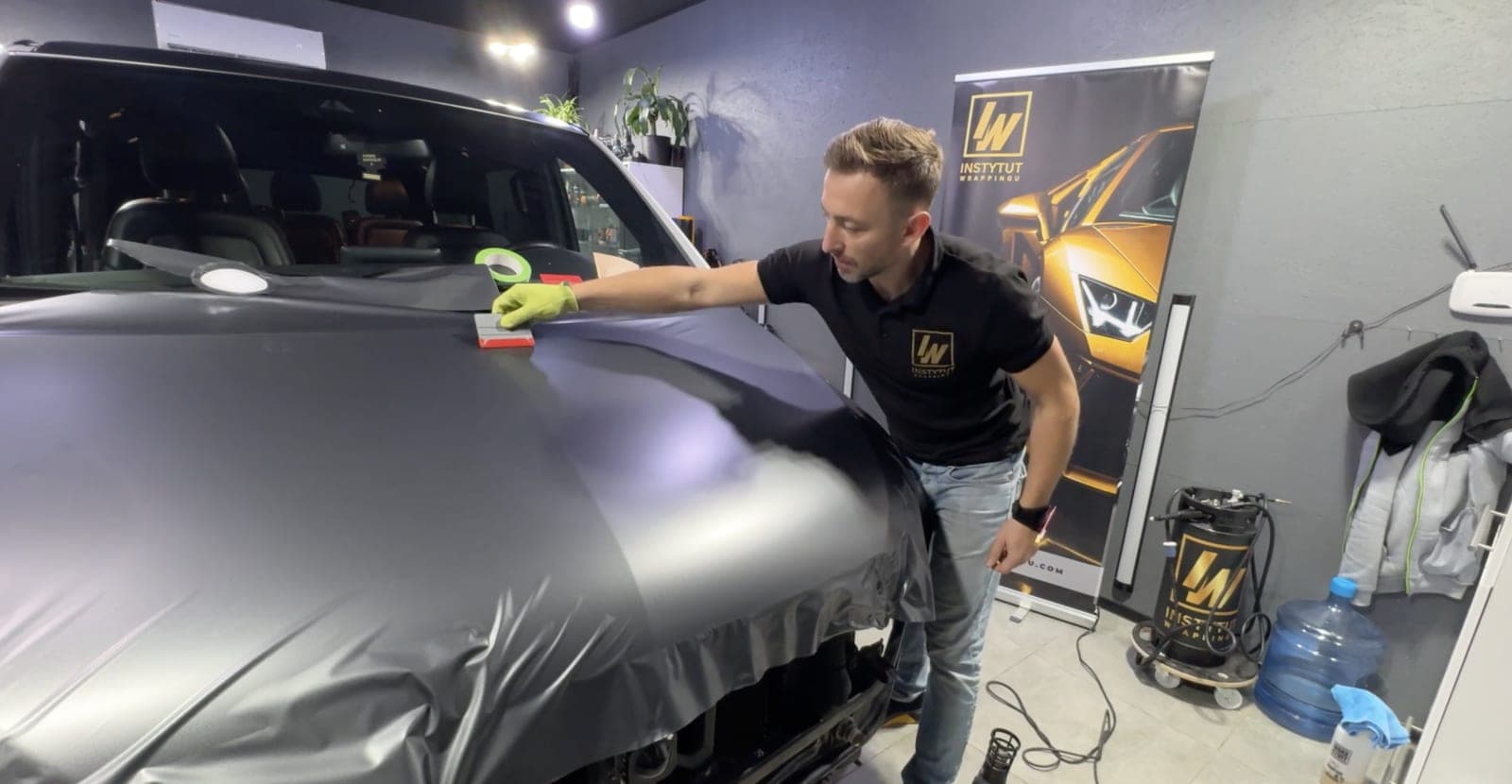 Cezary Mioduszewski okleja auto szarą folią w studiu Instytutu Wrappingu